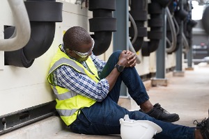 A man holds his knee after getting injured on the job. He'll need to call Rochford & Associates, a Workers Comp Lawyer in Peoria IL.