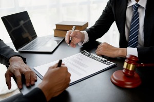 A lawyer from Rochford & Associates helps a person searching for a Car Accident Attorney in Peoria IL fill out paperwork