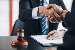 A lawyer shakes hands with a person who has been in a accident and deserves compensation. Get in touch with Rochford & Associates if you need a Motorcycle Accident Attorney in Peoria IL.