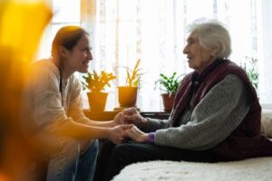 An elderly woman talks to her grandson while they hold hands at a nursing home. Rochford & Associates are Nursing Home Abuse Lawyers in Peoria IL.