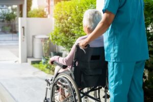 A nurse escorts a woman in a wheelchair. Rochford & Associates are Nursing Home Abuse Lawyers in Dunlap IL.