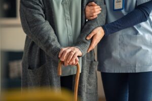 A nurse assists a senior woman with her walk. Rochford & Associates are Nursing Home Abuse Lawyers in Peoria IL.