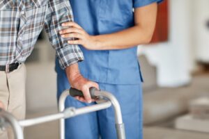 An elderly man receives assistance from a nurse. Rochford & Associates are Nursing Home Abuse Lawyers in East Peoria IL.