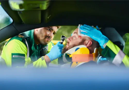 ER personnel help a man after a car accident. If you've been searching "How Do I File a Personal Injury Claim," call the legal team at Rochford & Associates.